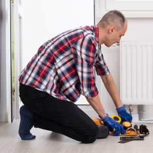 Central heating mechanic and handyman fixing home radiator, gas crisis and seasonal issues.