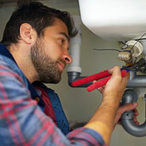 Hes a pro at plumbing. Shot of a plumber fixing a pipe.